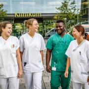 Vier Kolleg/innen vor dem Hauptgebäude der Rems-Murr-Kliniken Winnenden